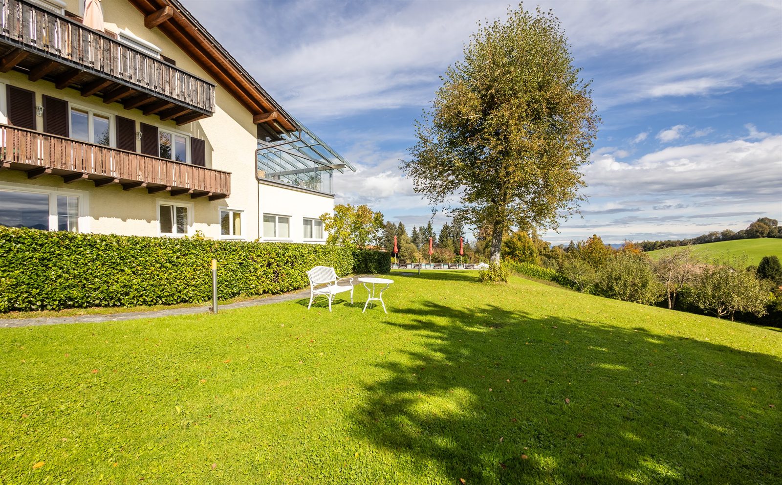 Hausansicht mit Wiese und Wintergarten