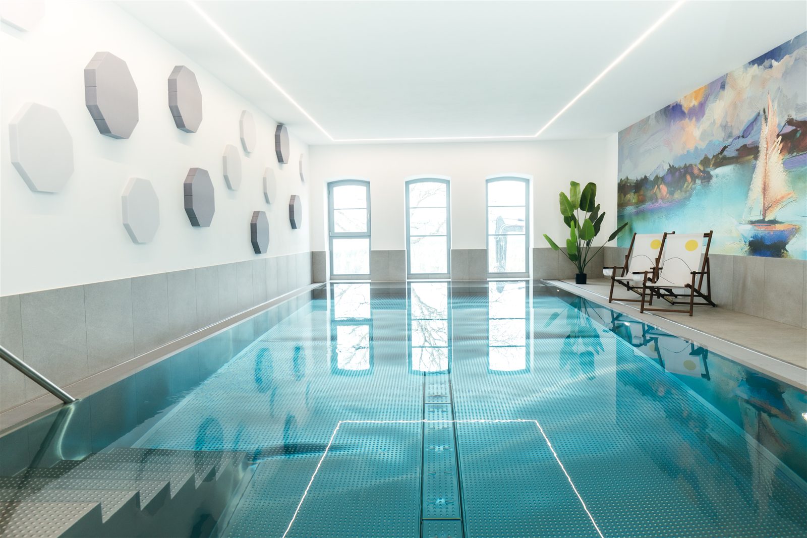 Schwimmbad mit Liegen und Tageslicht