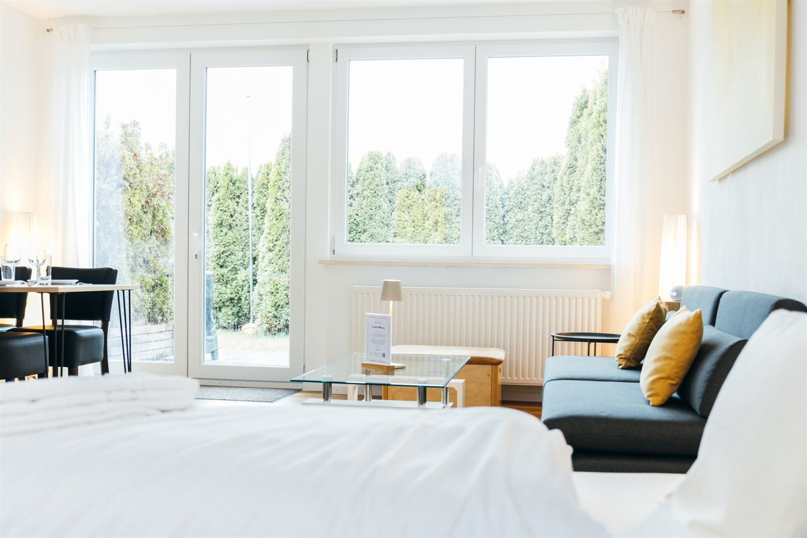 Studio · Vom Bett aus geht der Blick durch die Fensterfront auf die Terrasse