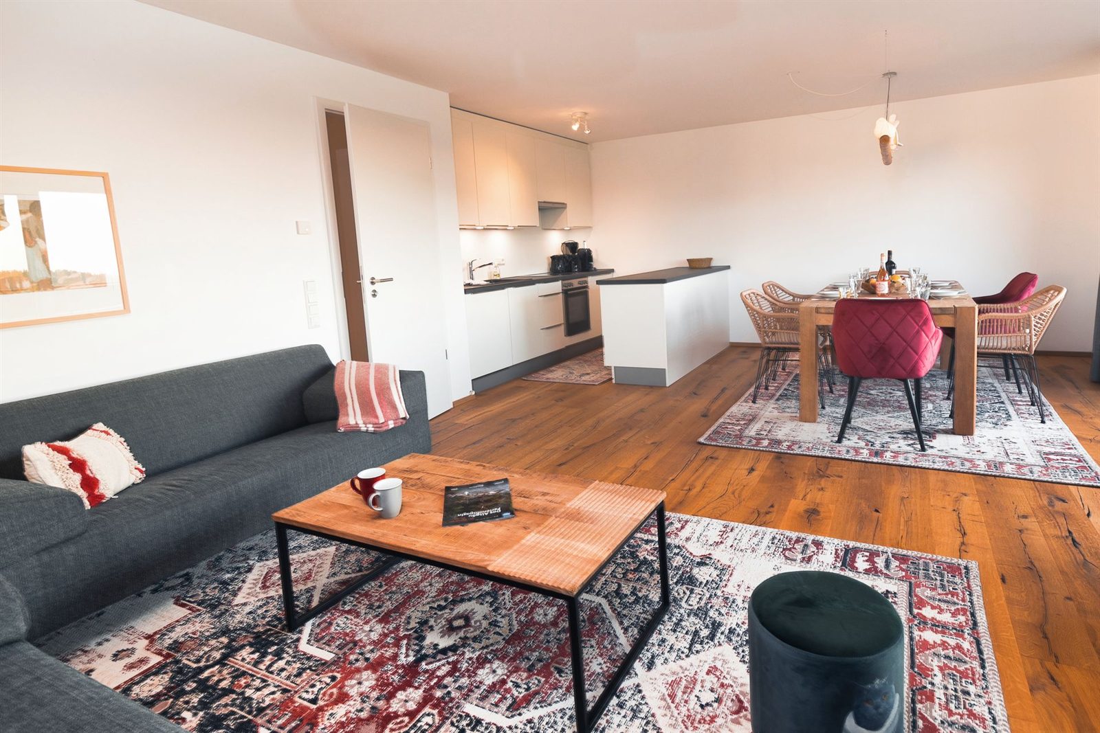 Wohnraum · Zwei Sofas, dahinter die Küchenzeile mit Tresen und der Esstisch