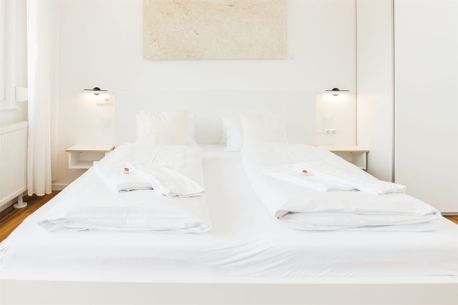Schlafbereich · Doppelbett mit Wandleuchten und Ablagen, rechts der Kleiderschrank