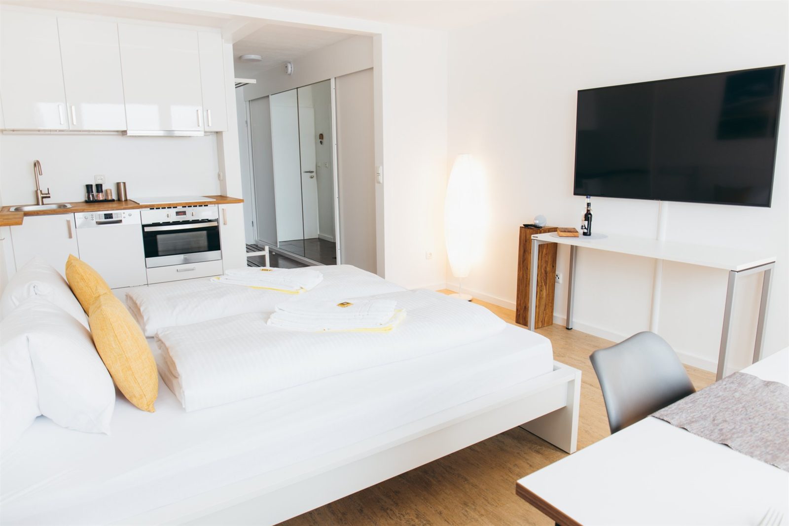Studio · Küche mit Backofen neben dem Bett, gegenüber der große Smart-TV