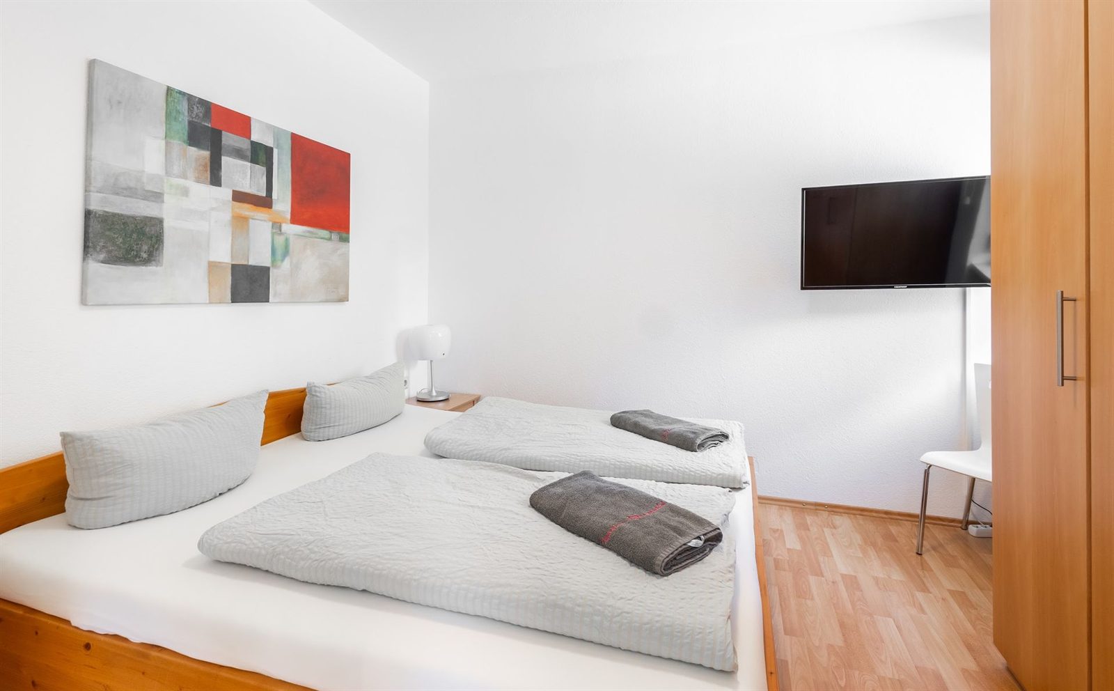 Schlafzimmer · Doppelbett mit Holzrahmen, gegenüber der Fernseher