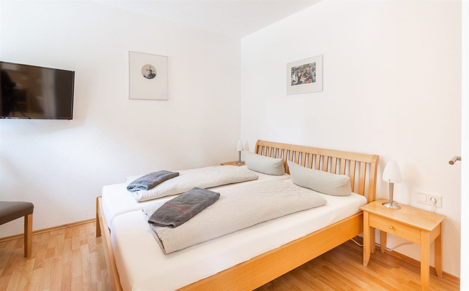 Schlafzimmer · Doppelbett mit Holzkopfteil, gegenüber der Fernseher