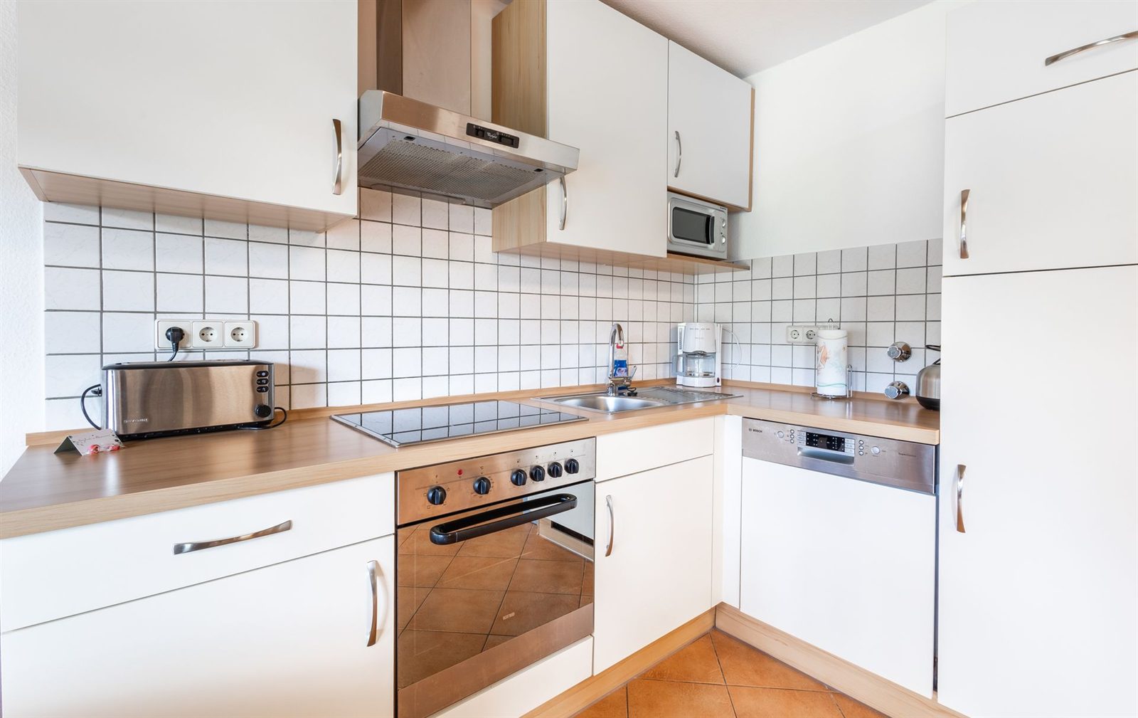Küche · Backofen, Ceranfeld, Spüle und Geschirrspüler über Eck, dazu Mikrowelle, Kaffeemaschine und Toaster