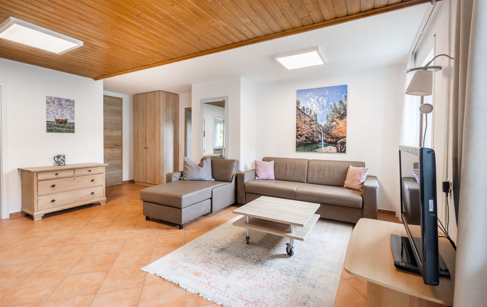Wohnzimmer · Das Ecksofa lässt sich ausklappen, daneben Kommode und Kleiderschrank
