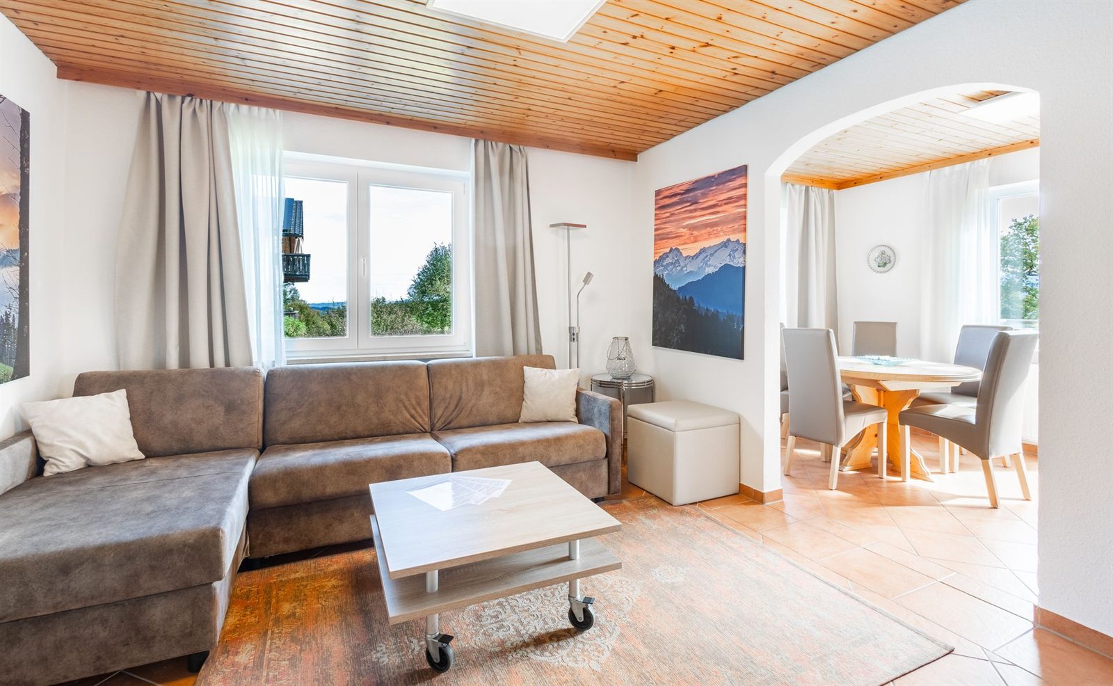Wohnzimmer · Ecksofa unter der Holzdecke, durch den Rundbogen geht es zum Essplatz