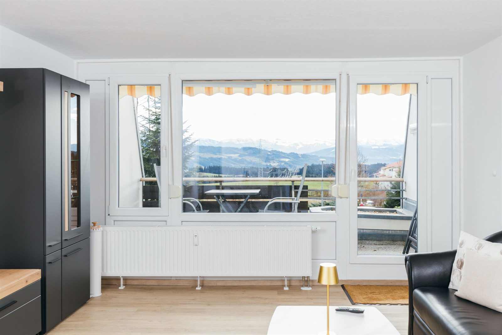 Aussicht · Von der Fensterfront geht der Blick über das Tal bis zu den schneebedeckten Gipfeln
