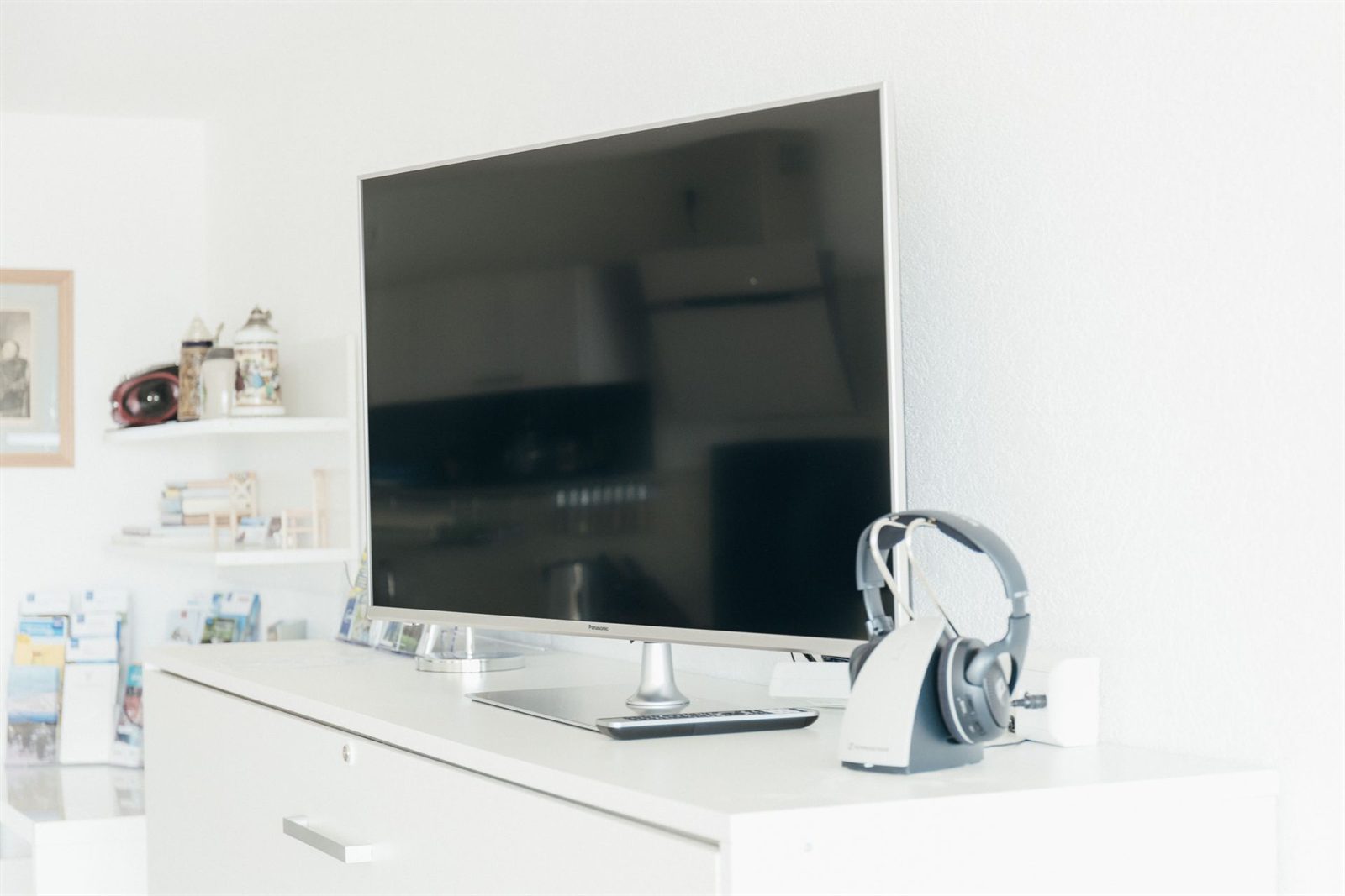 Wohnbereich · Fernseher auf dem Sideboard, daneben ein Funkkopfhörer für späte Abende