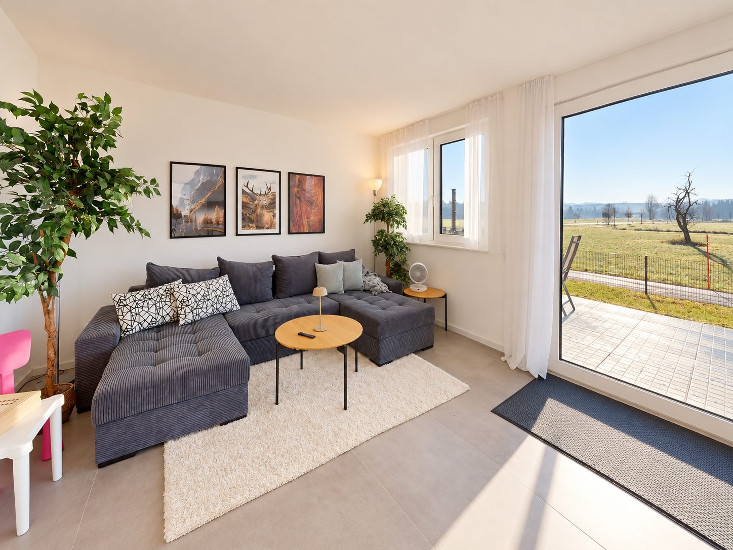 Wohnzimmer mit großem Ecksofa und Tür zur Terrasse