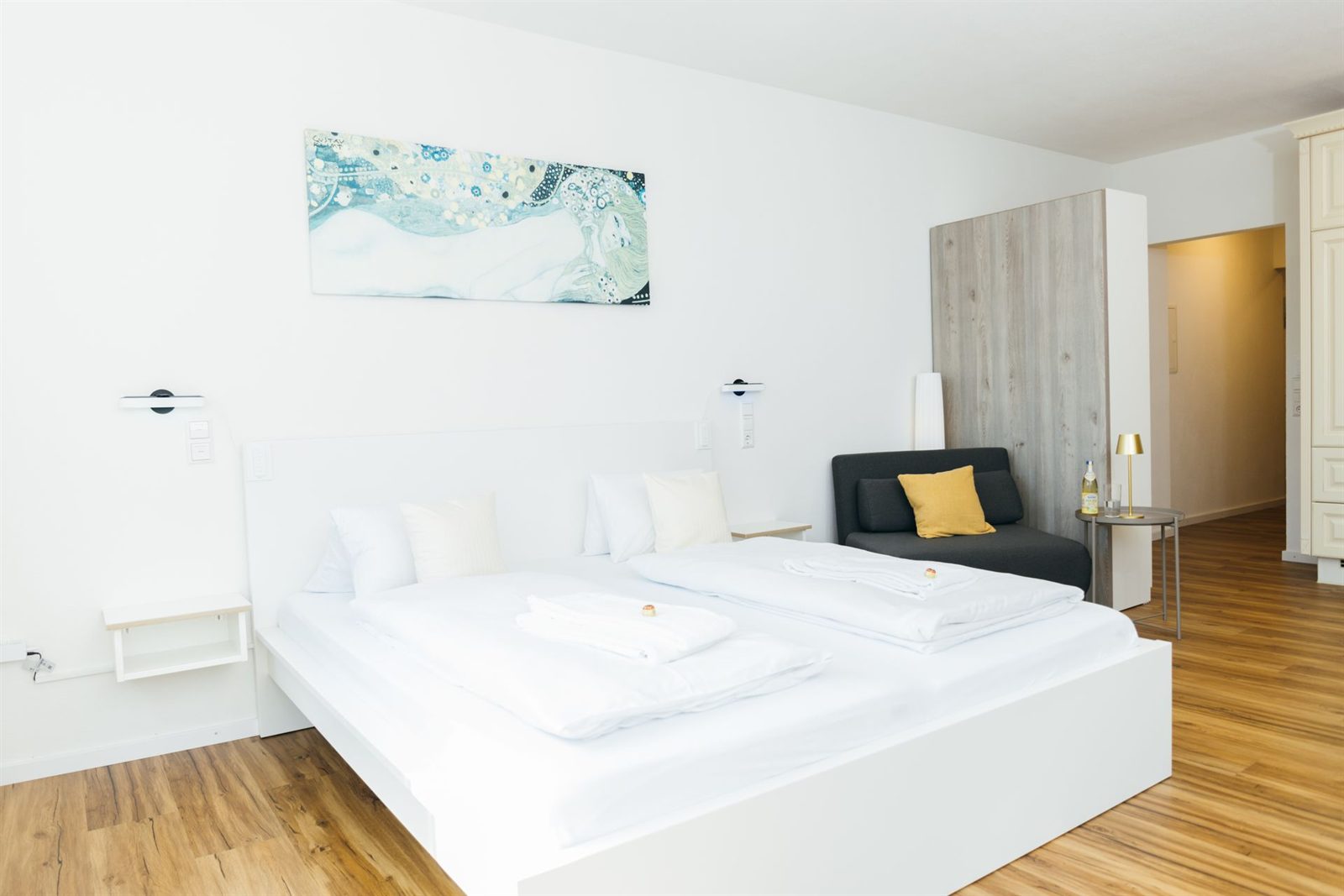 Wohnraum · Doppelbett mit Wandleuchten, daneben der Schlafsessel und der Kleiderschrank