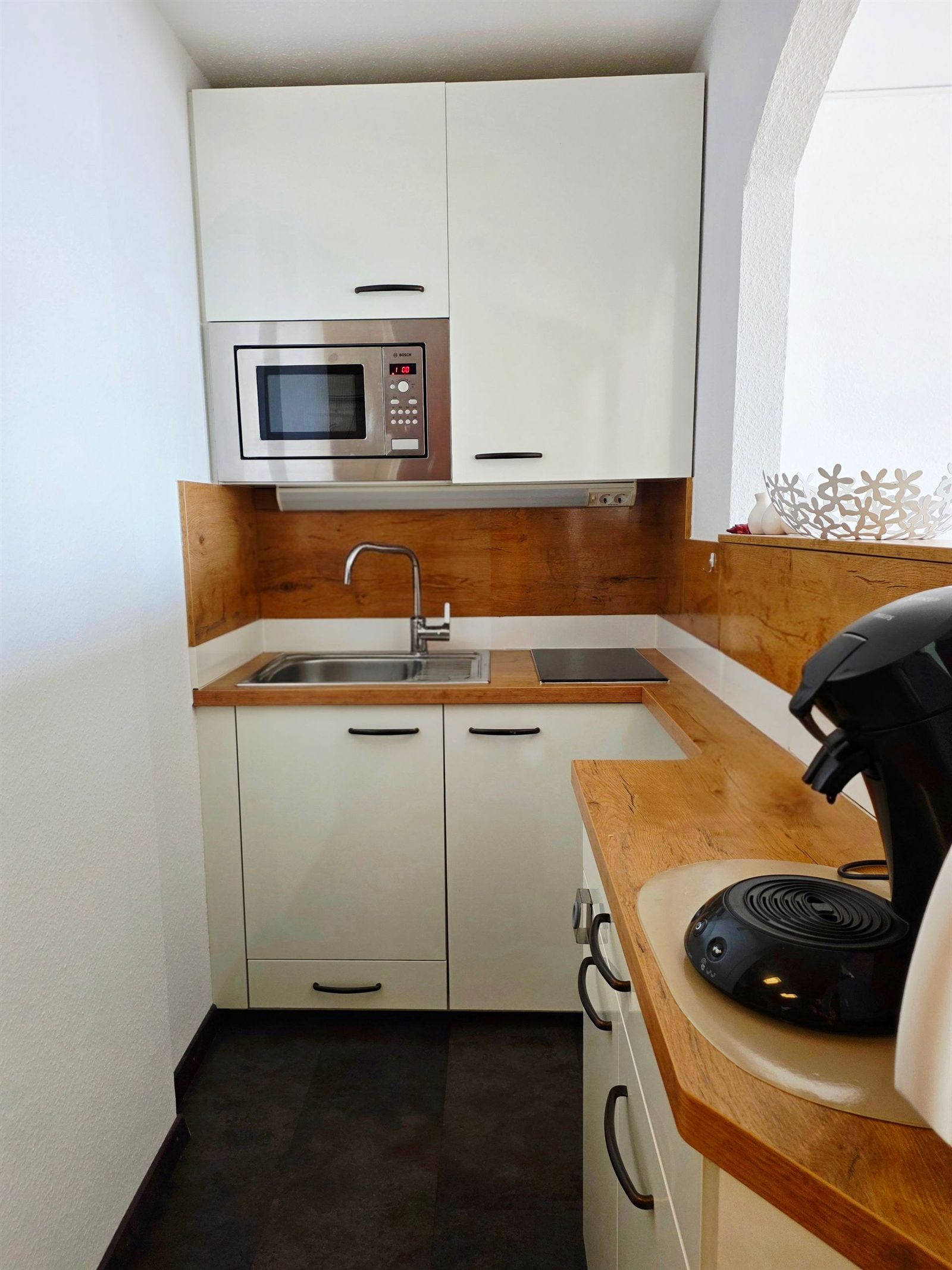Küche · Eigener kleiner Raum mit Spüle, zwei Kochplatten, Mikrowelle und Kaffeepadmaschine